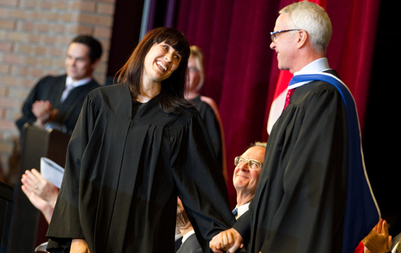Dean W. Iain Scott congratulates a student as she walks across the stage at Althouse College