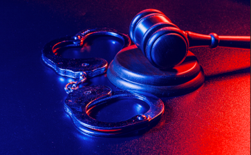 Handcuffs and a gavel with red and blue colouring